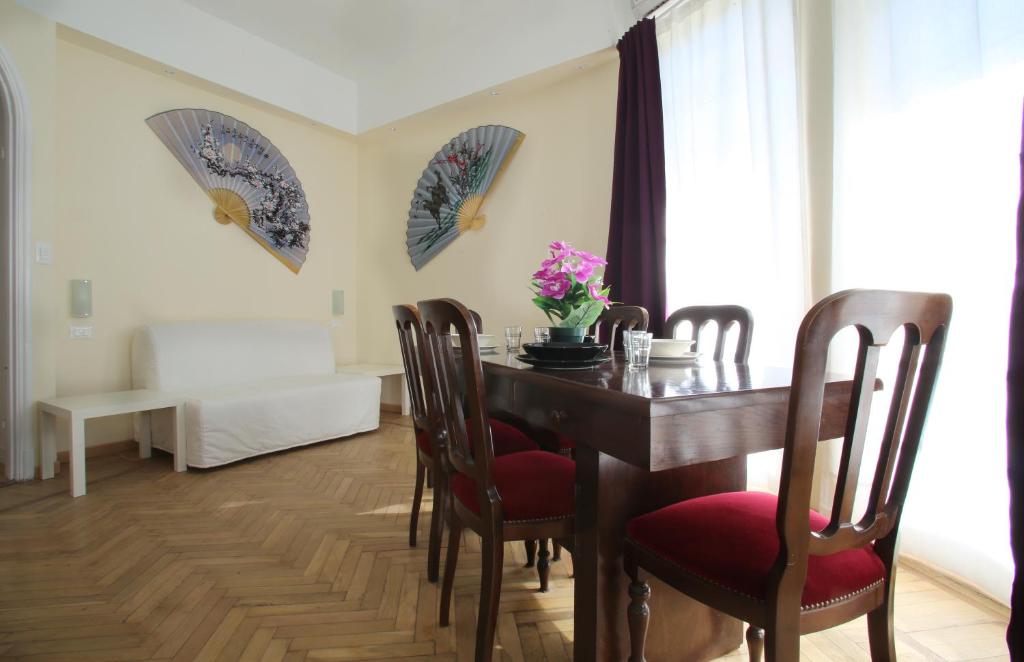 ein Esszimmer mit einem Holztisch und Stühlen in der Unterkunft 53 Solaro Apartments in Sanremo