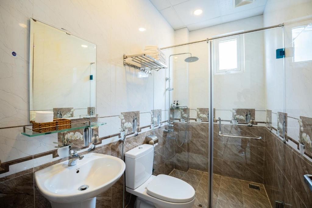 La salle de bains est pourvue de toilettes, d'un lavabo et d'une douche. dans l'établissement Tuấn An Hotel, à Đà Lạt