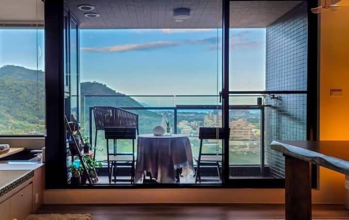 uma sala de jantar com mesa e cadeiras na varanda em 浮雲投影海景溫泉 em Toucheng