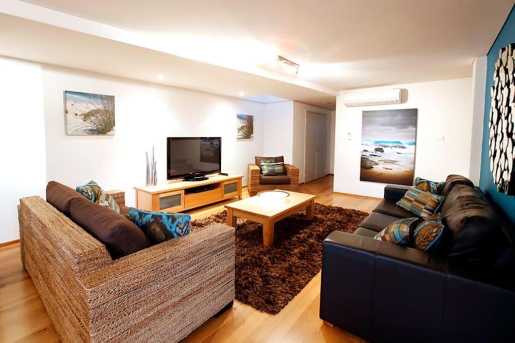 uma sala de estar com dois sofás e uma televisão em Apt 8 'Aquilla' @ Bay View Centro, Dunsborough em Dunsborough