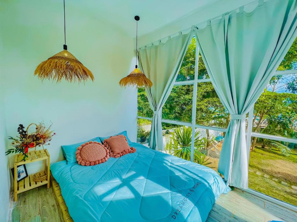 - une chambre avec un lit bleu et une grande fenêtre dans l'établissement Chon's Dock Homestay & Apartment For Lease, à Phan Thiết