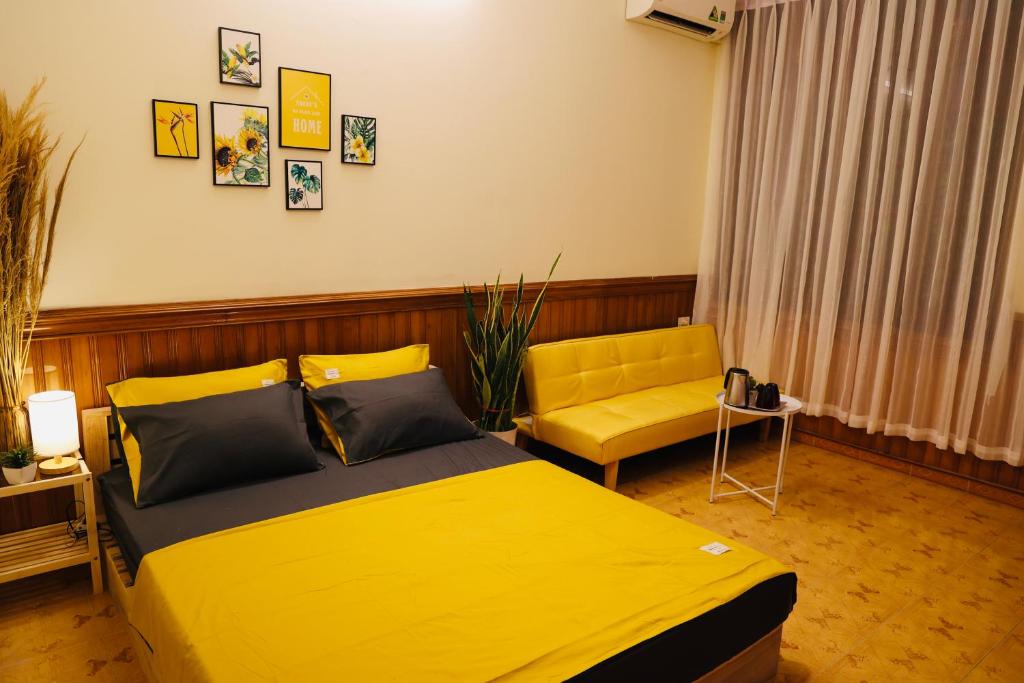 a bedroom with a yellow bed and a yellow chair at Homestay cạnh Lăng Bác in Hanoi
