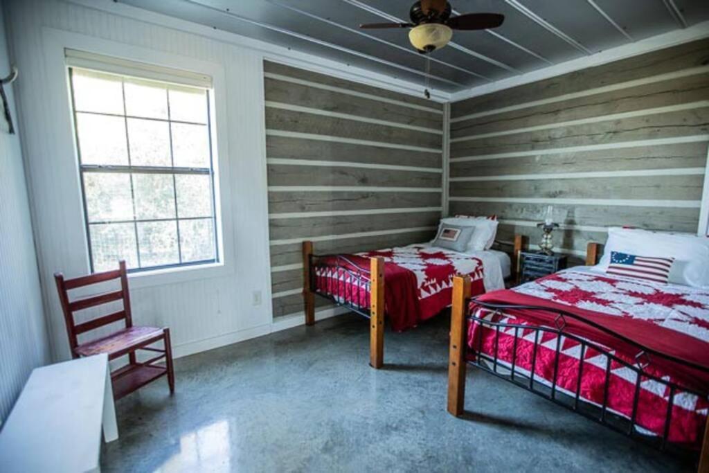 RoznovにあるSaddle Creek Cabinsのベッドルーム1室(ベッド1台、椅子、窓付)