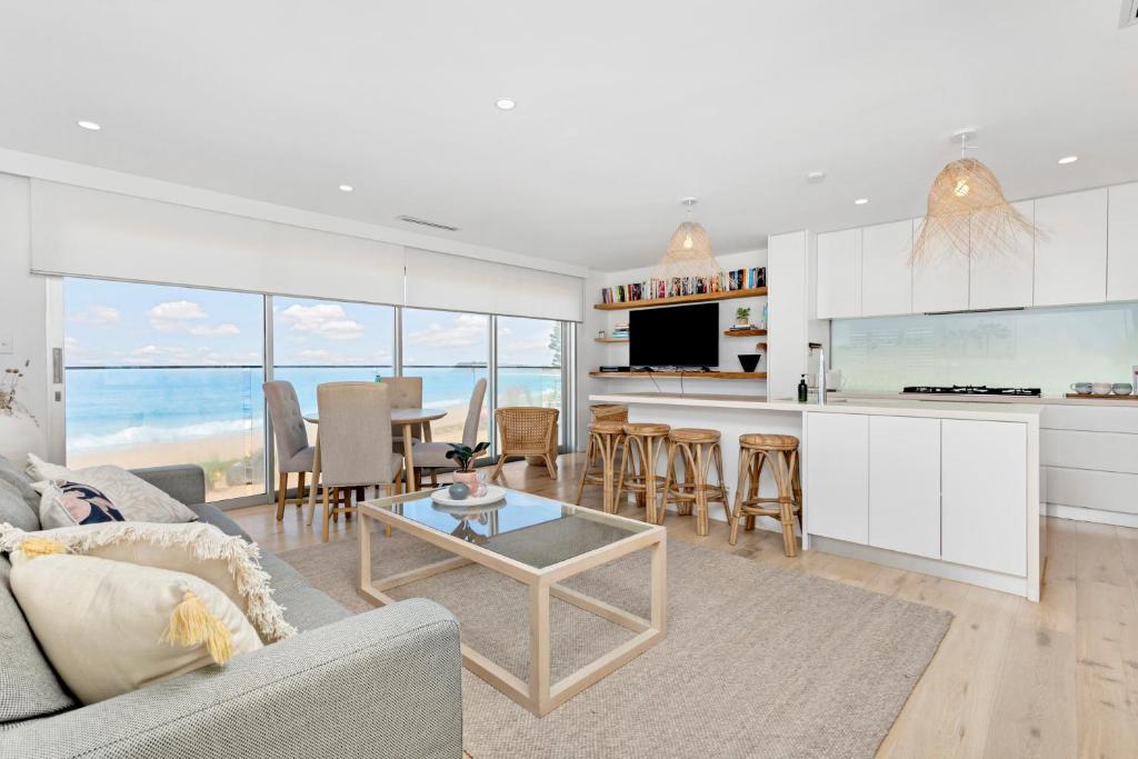 a living room with a couch and a table at Collaroy Beachfront Escape - New Listing in Collaroy