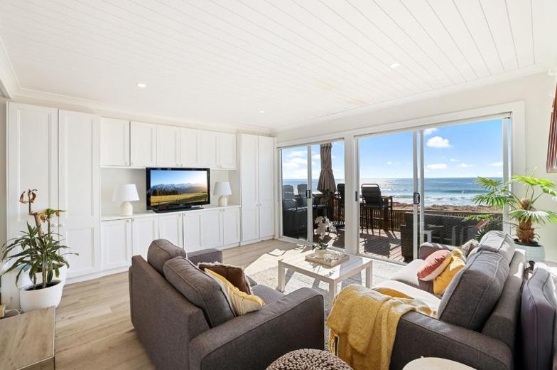 a living room with two couches and a view of the ocean at Collaroy Beachfront Hideaway - Parking and views in Collaroy