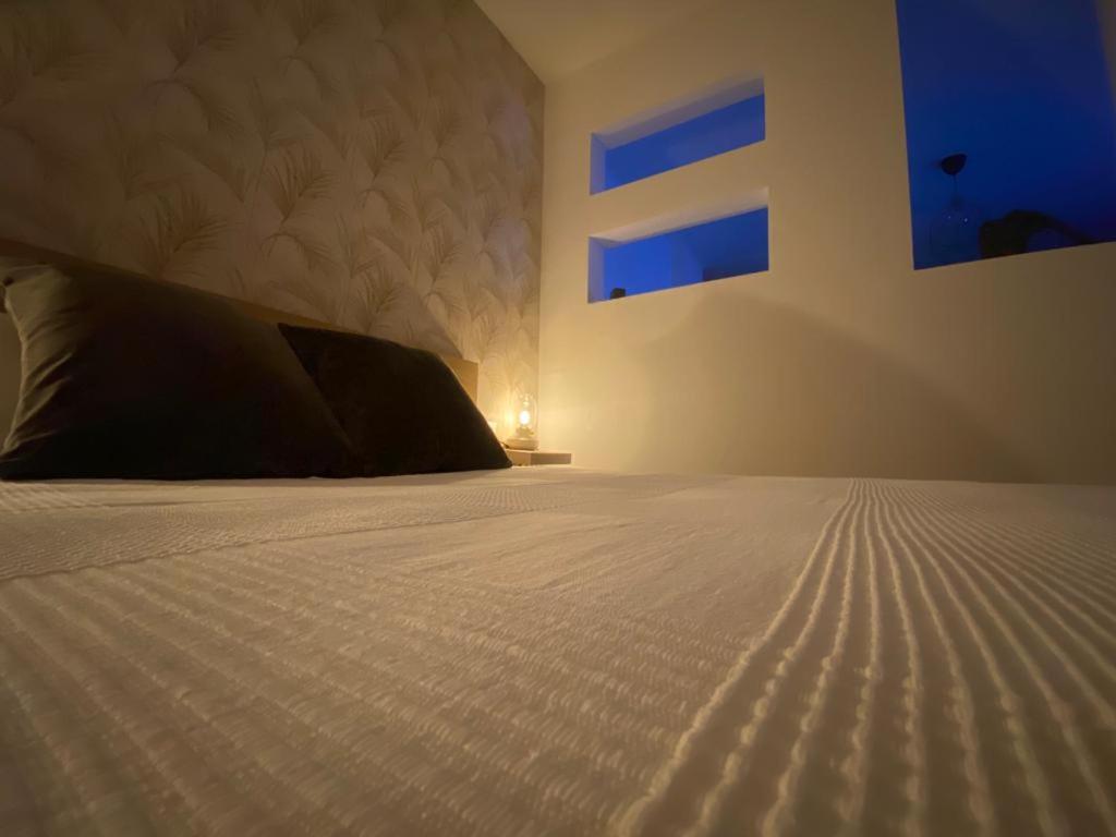 a bedroom with a bed with a white comforter at La Lunita in Valverde