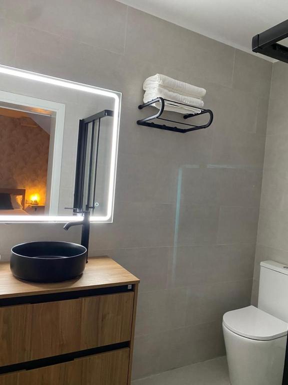 a bathroom with a sink and a mirror and a toilet at La Lunita in Valverde