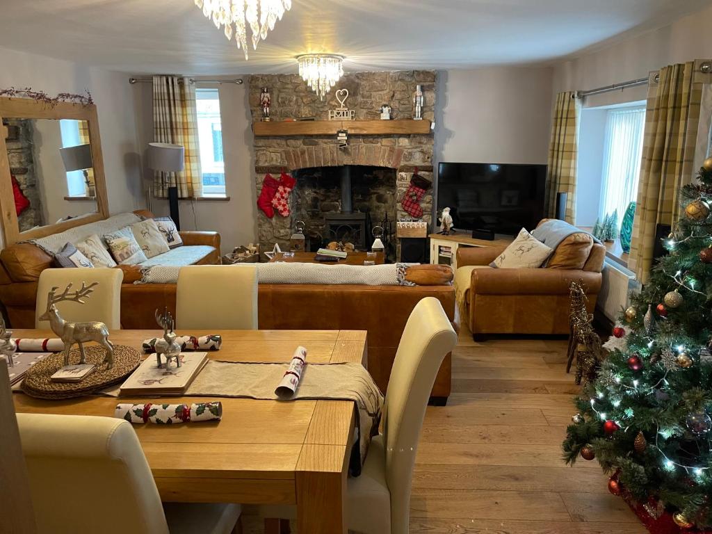 a living room with a christmas tree in it at Honeycott in Crickhowell