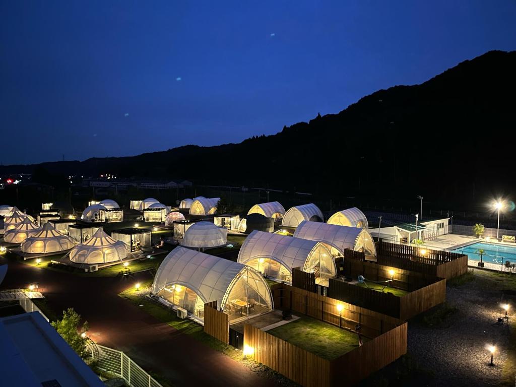a group of domed buildings at night at Glamping&Port結 in Shimada