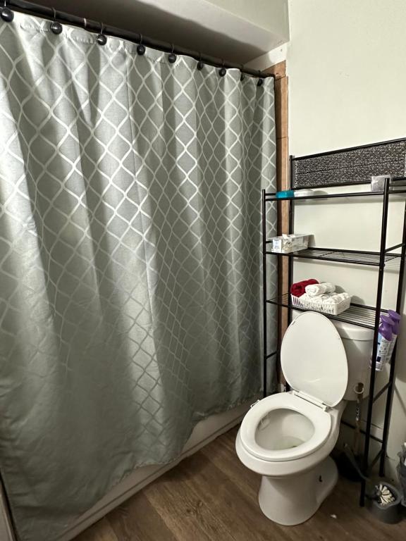 ein Bad mit einem Duschvorhang und einem WC in der Unterkunft Small Paradise in Indiantown