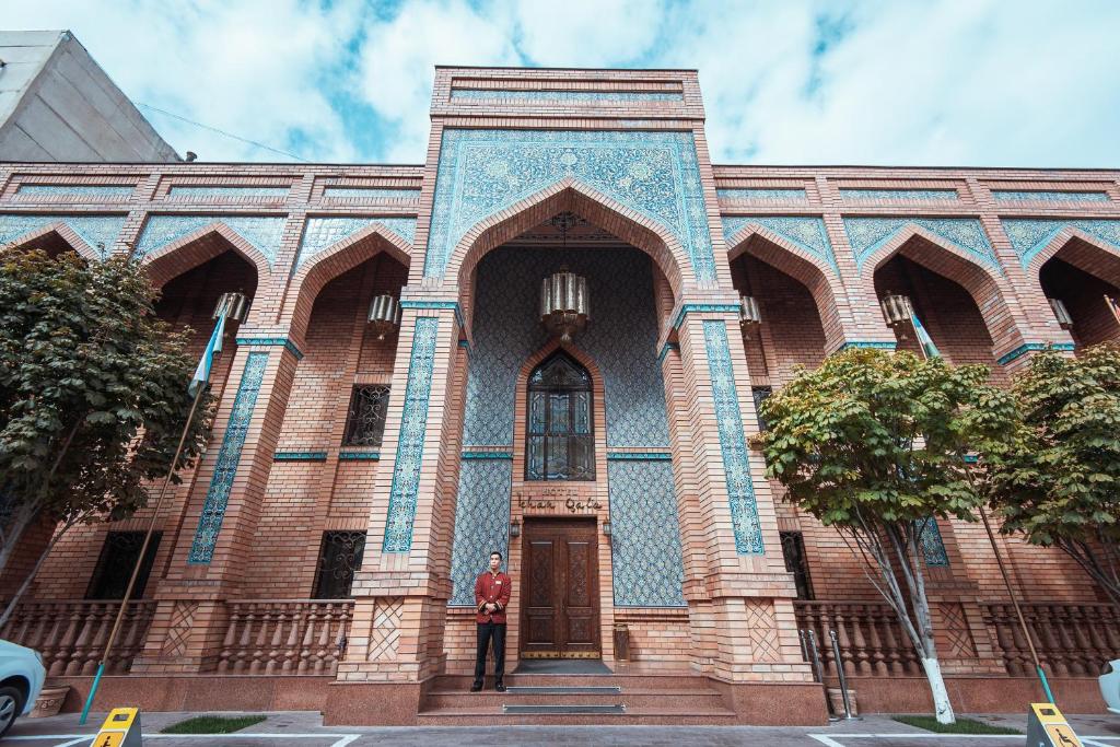 a man standing in front of a church at Ichan Qal'a Premium Class Hotel in Tashkent
