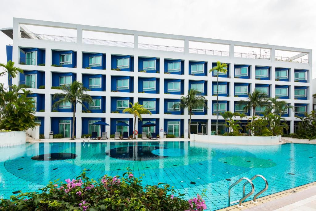 a hotel with a large swimming pool in front of a building at Republic of Singapore Yacht Club in Singapore