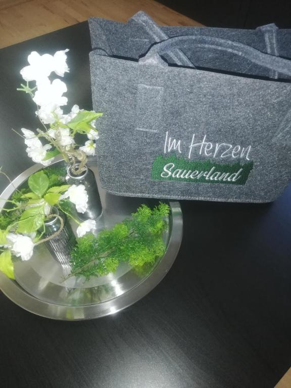 a bowl of flowers and a box on a table at Ferienwohnung Sauerland in Drolshagen