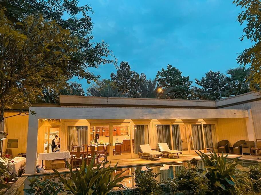 una casa con patio arredato con tavolo e sedie di Riverside French Villa a Thuan An