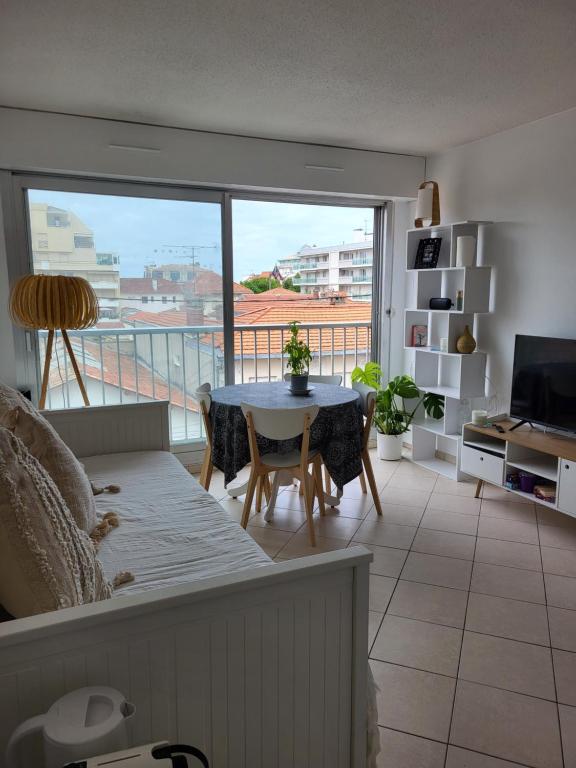 un salon avec une table et une grande fenêtre dans l'établissement Au bord de l'eau rend la vie à Arcachon, à Arcachon