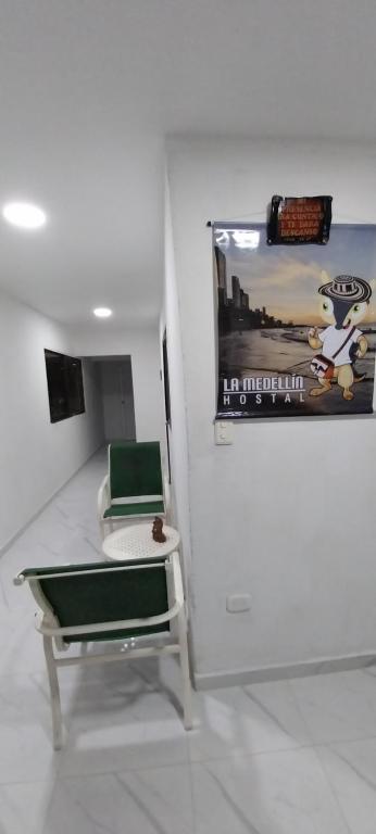 um quarto com uma cadeira e um quadro na parede em LA MEDELLIN HOSTAL em Cartagena das Índias