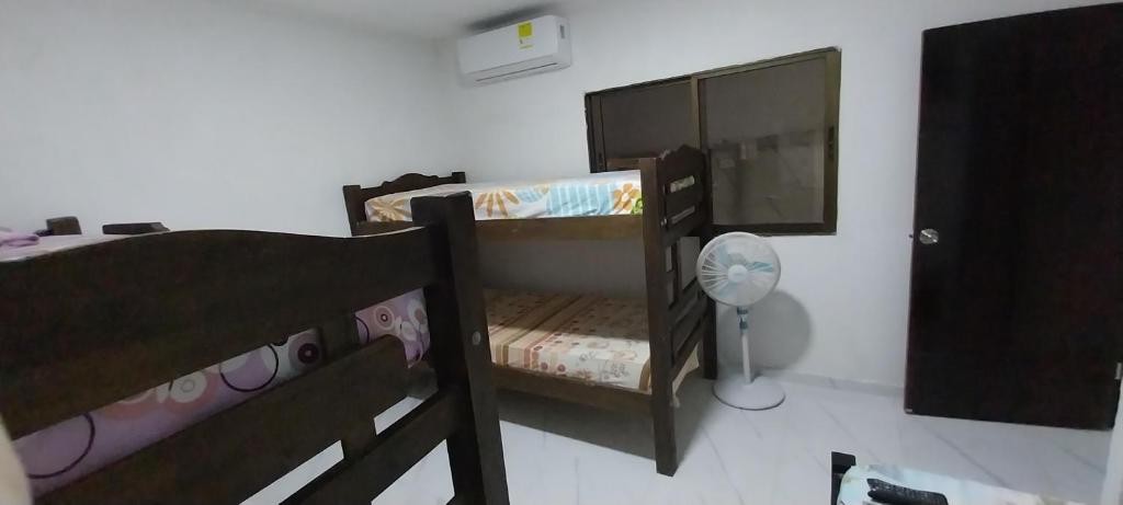 two bunk beds in a room with a fan at LA MEDELLIN HOSTAL in Cartagena de Indias