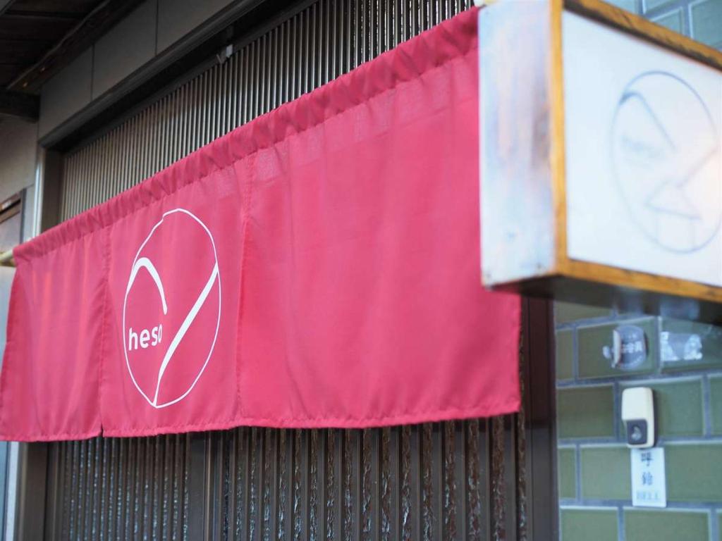 a red banner on a building with a no smoking sign at 四国旅行のHUB拠点 古民家ゲストハウスheso house in Miyoshi