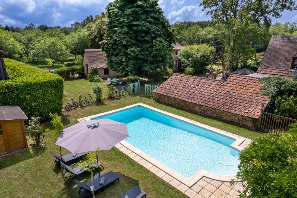 vista sulla piscina con ombrellone di The cottage at Les Chouettes Tremolat a Trémolat