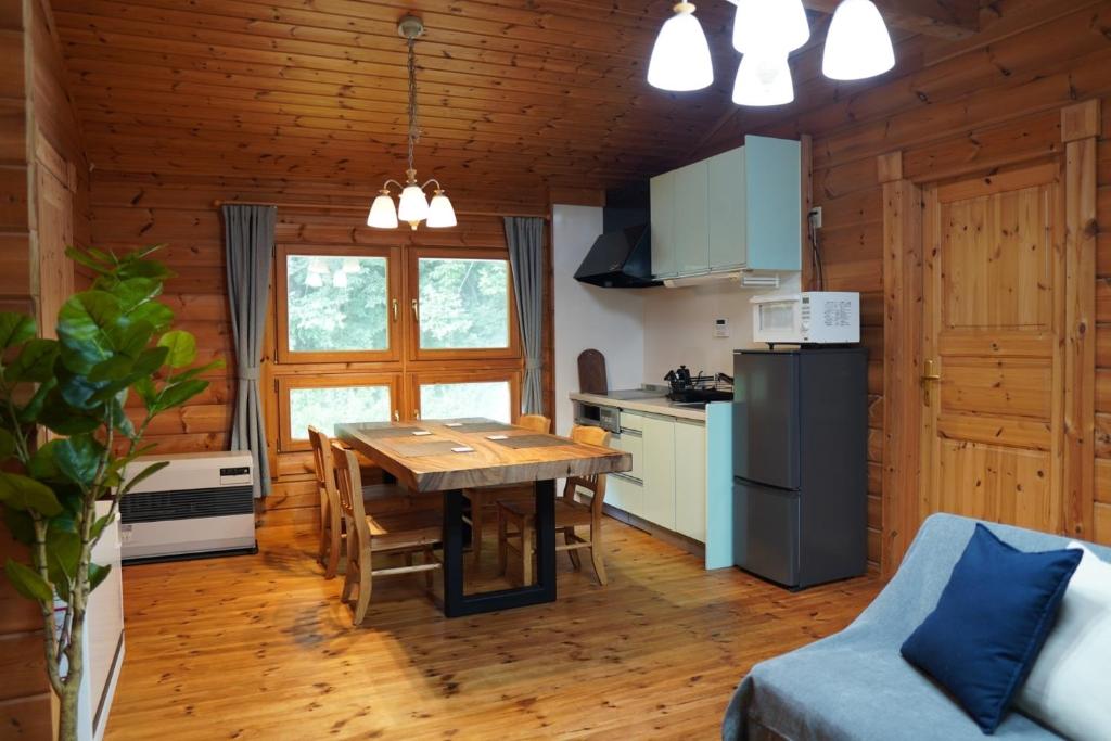 a kitchen and dining room with a table in a cabin at ＯＮＶＯ ＳＴＡＹ ８ in Hokuto