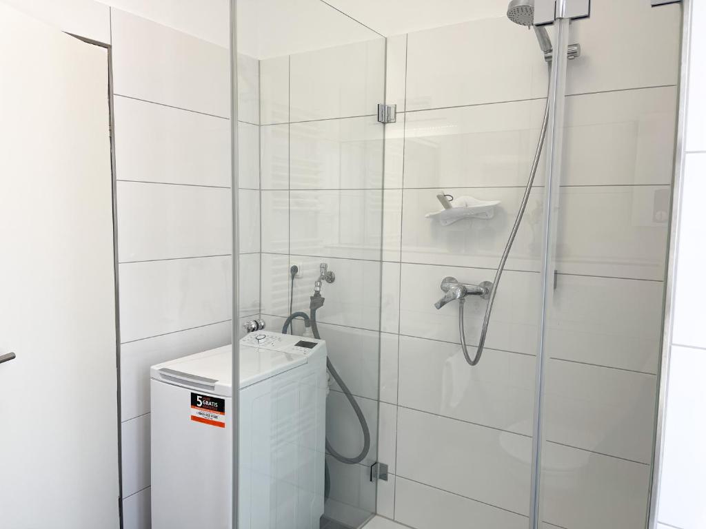 a white bathroom with a shower and a sink at Praktisch & modern - voll ausgestattetes Apartment in Stolberg