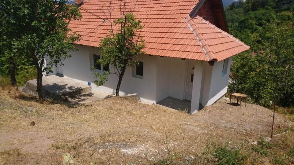 una pequeña casa blanca con techo naranja en Lenka, en Višegrad