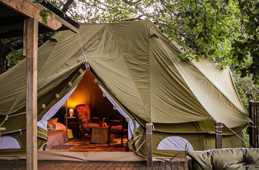 une tente verte avec un salon à l'intérieur dans l'établissement TENTE HERISSON BOHEME 4 PERSONNES Camping Lou cantou Cévenol, à Anduze