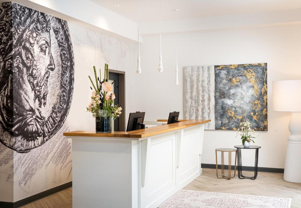 an office with a reception desk and a painting on the wall at elaya hotel regensburg city center in Regensburg