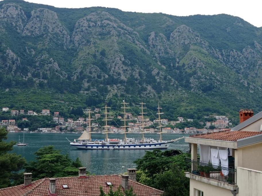 un grand bateau dans une grande étendue d'eau avec des montagnes dans l'établissement M&M Apartment, à Kotor