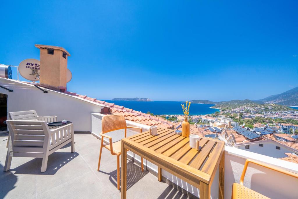 a balcony with a table and chairs and a view of the ocean at Bella Kaş in Kaş