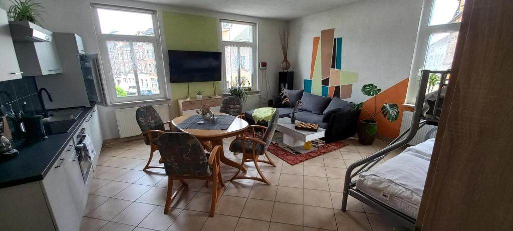 a kitchen and living room with a table and chairs at Ferienwohnung Perse in Lengenfeld