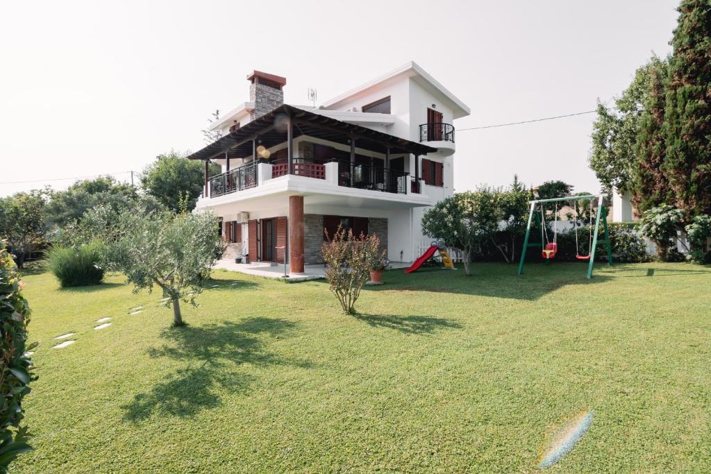 una casa con un cortile con un'altalena di Theoni’s country house with garden and sea view a Alexandroupoli
