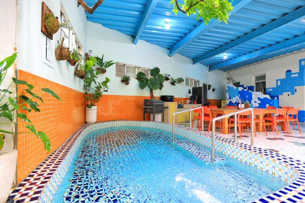 una piscina en una habitación con mesa y sillas en Fumigate Hotel, en Hengchun
