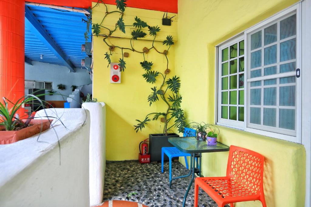 a room with a table and chairs and a yellow wall at Fumigate Hotel in Hengchun South Gate