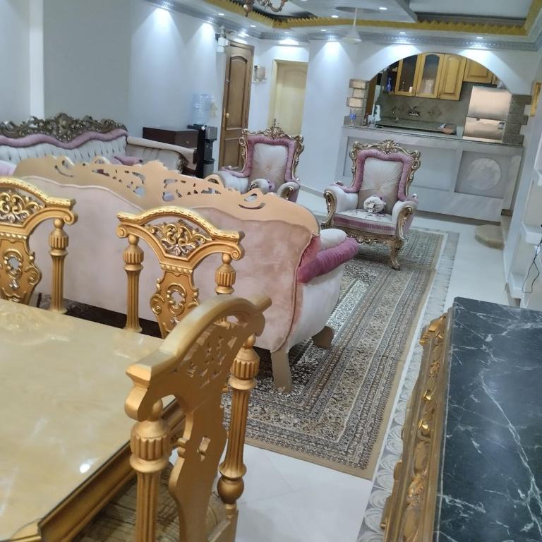 a room with a bed and chairs and a table at شقة مفروشة سوبر لوكس للايجار in Cairo