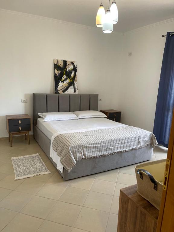 - une chambre avec un grand lit et des rideaux bleus dans l'établissement Sunrise Golem Summer Apartment, à Durrës