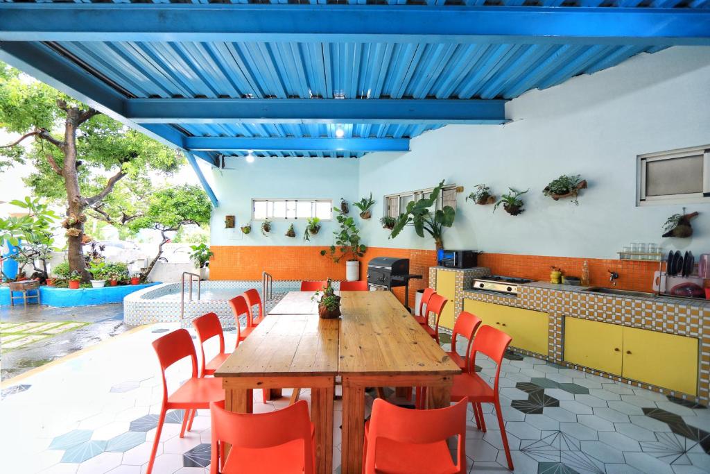 a dining room with a wooden table and red chairs at Fumigate Hotel in Hengchun South Gate