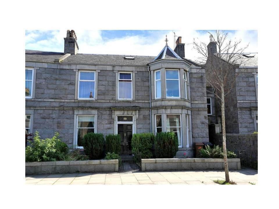 een groot bakstenen huis met een boom ervoor bij 26 Belvidere Crescent Apartment in Aberdeen