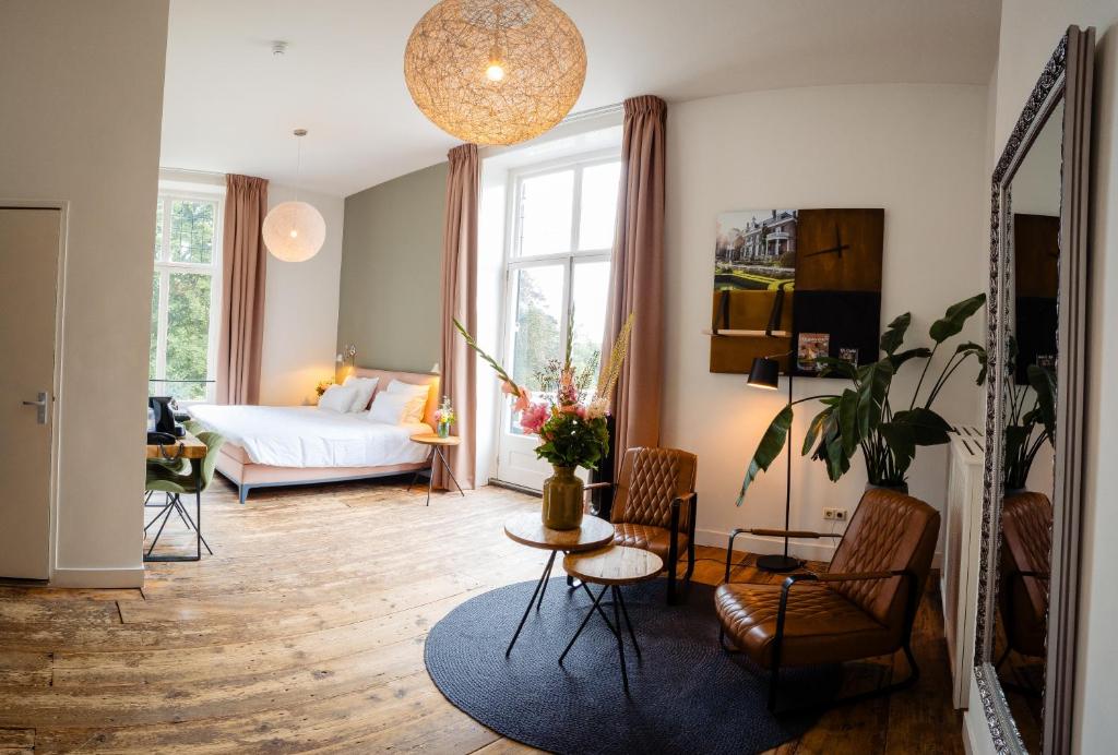 een woonkamer met een bed en een tafel en stoelen bij Landgoed Rhederoord nabij Arnhem in De Steeg