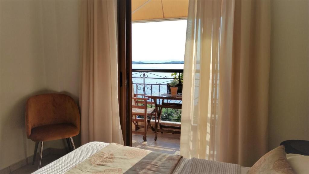 a bedroom with a bed and a view of a balcony at Pansion Katerina in Ouranoupoli
