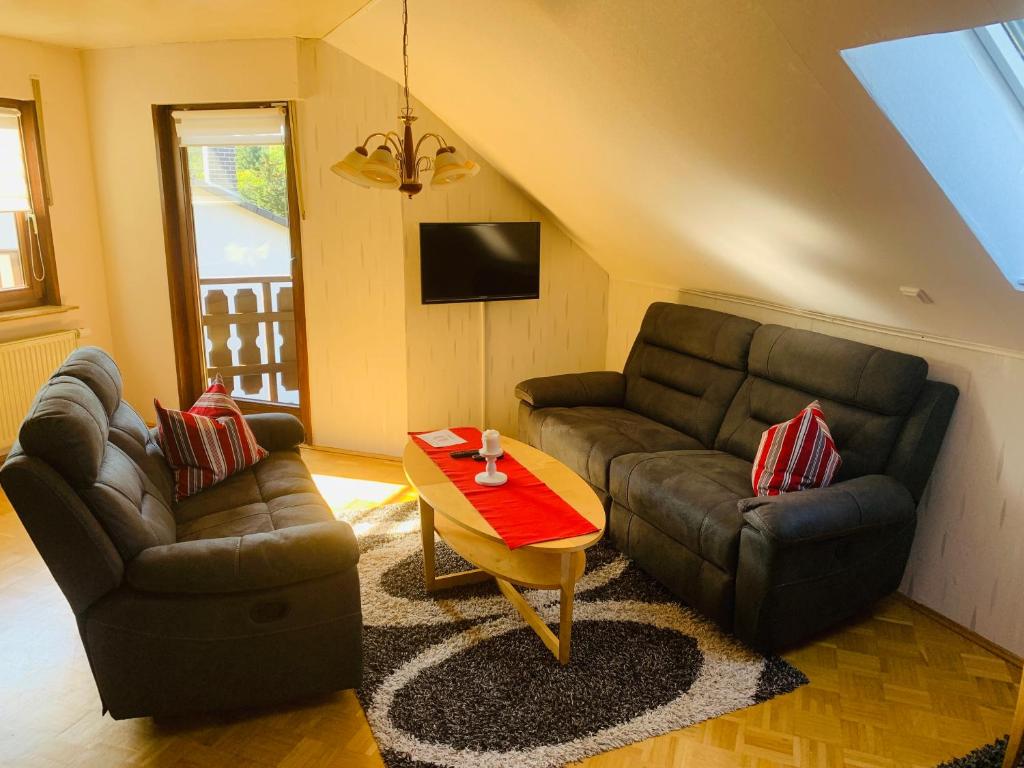 uma sala de estar com dois sofás e uma mesa em Ferienwohnung Braeuer em Chemnitz