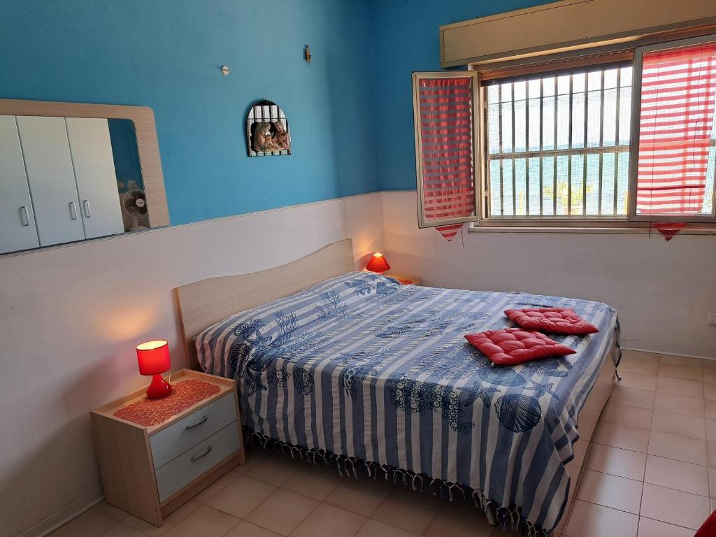 a bedroom with a bed with red pillows on it at Villino Relax in Portopalo