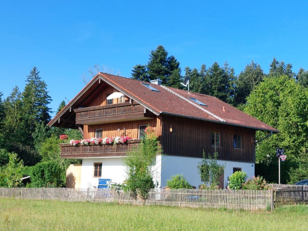 a house with a wooden roof and a fence at Ferienwohnung Holzmaier in Bad Aibling