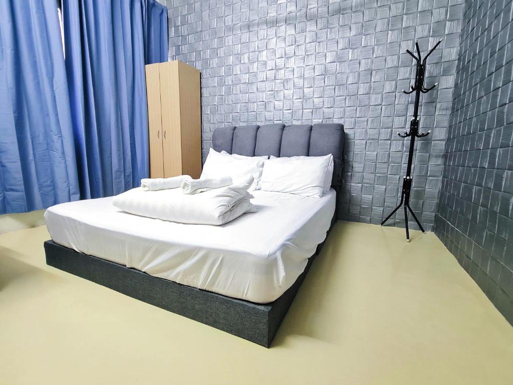 een bed met een blauw hoofdeinde in een kamer bij Cozy n Quiet home near to BKE Highway n Kulim High Tech Park in Lunas