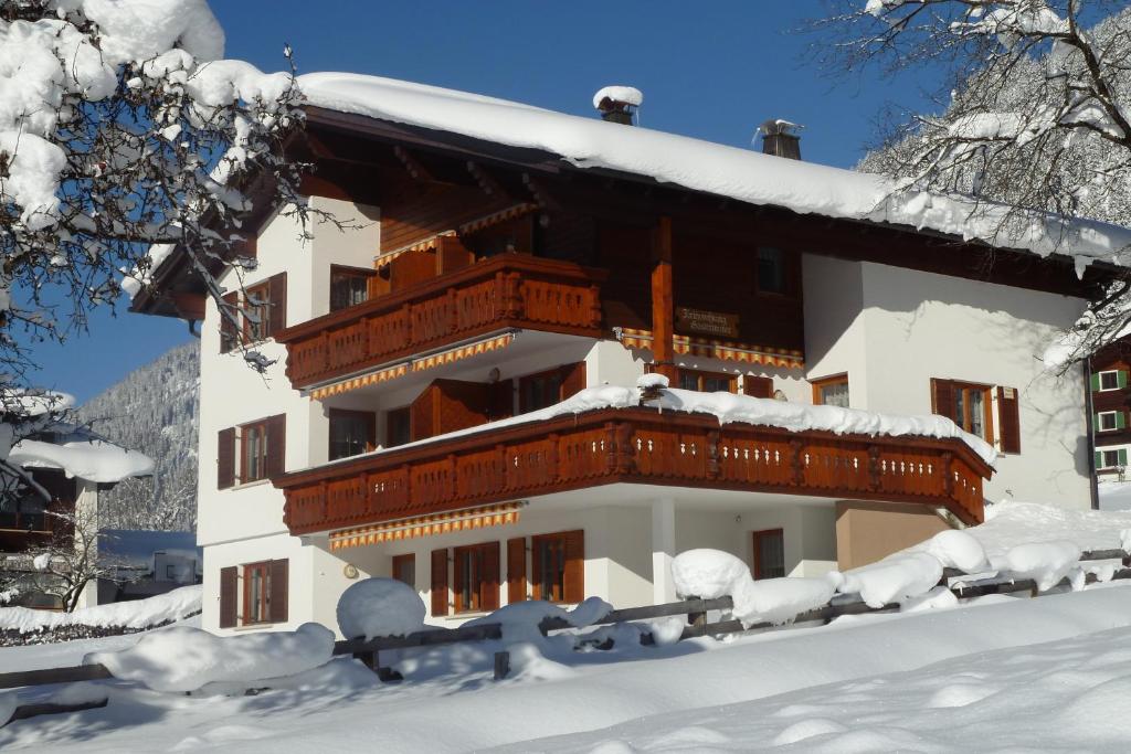 un edificio cubierto de nieve con árboles nevados en Haus Obere Allmein, en Sankt Gallenkirch