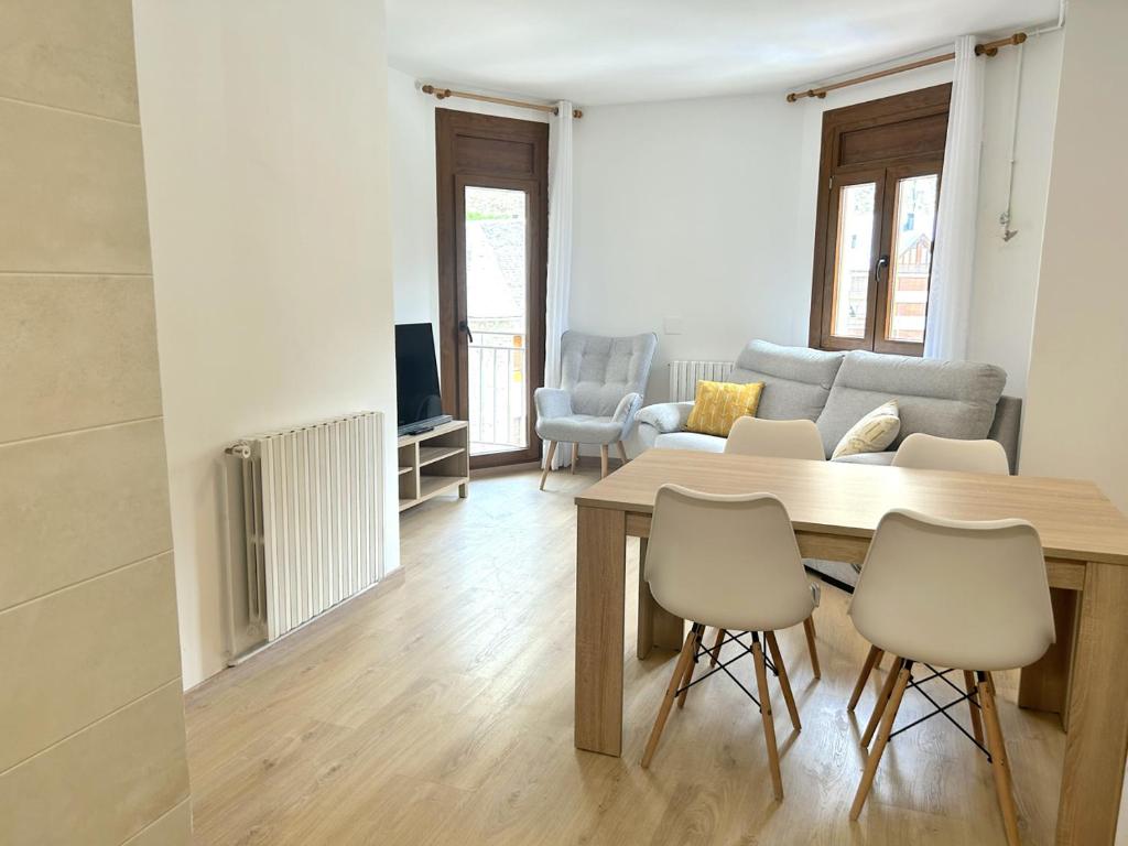 sala de estar con mesa, sillas y sofá en Apartament comfortable amb vistes i cèntric by RURAL D'ÀNEU, en Esterri d'Àneu