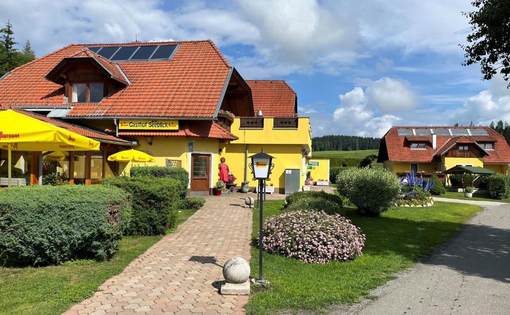 una casa amarilla con paneles solares en el techo en Hotel Gasthof Seeblick en Zeutschach