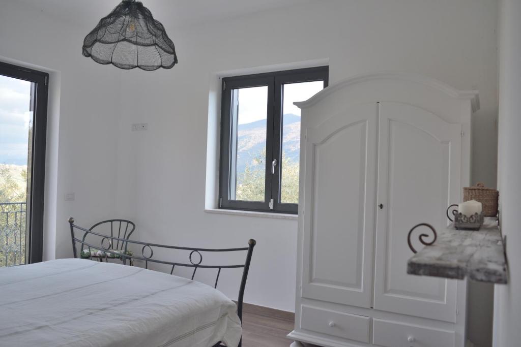 ein weißes Schlafzimmer mit einem Bett und einem Fenster in der Unterkunft La Rosa di Tempalta in Albanella