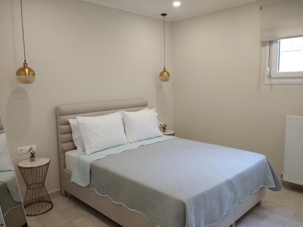 a bedroom with a bed with white sheets and pillows at Oasis Apartments in Áyios Andréas