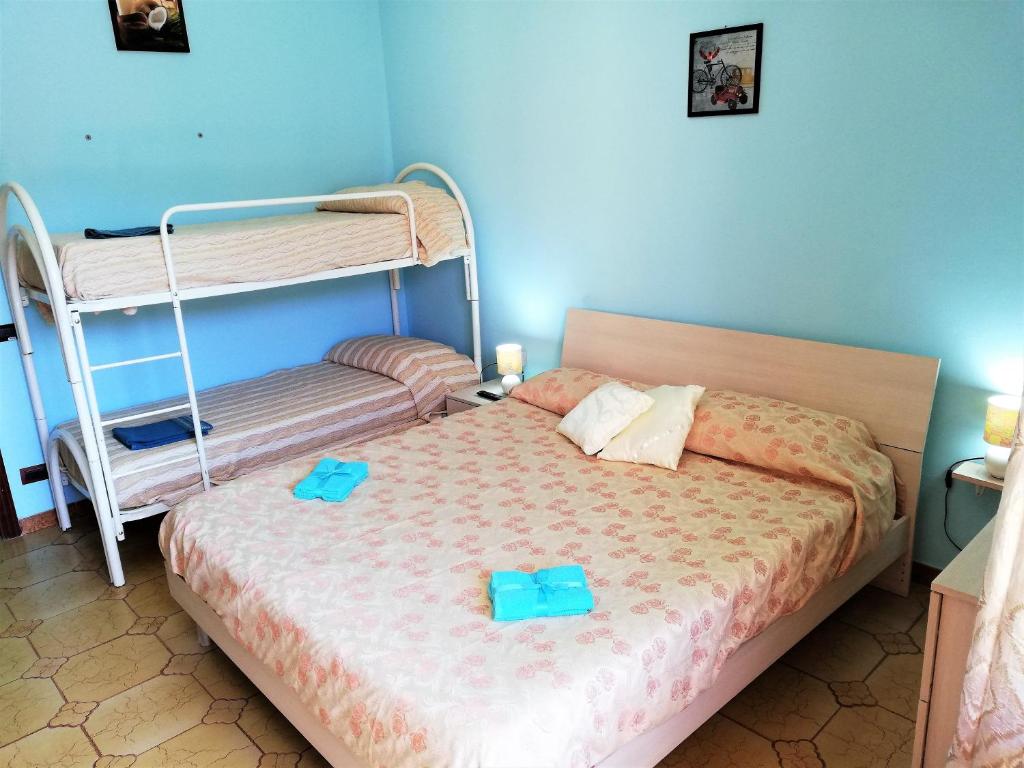 een slaapkamer met een bed en een stapelbed met blauwe muren bij Via Pisa in Riposto